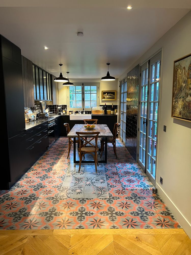 The kitchen with encaustic cement tiles and a long farmhouse table